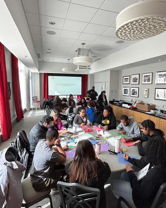 Students working on a project while speaker guide them